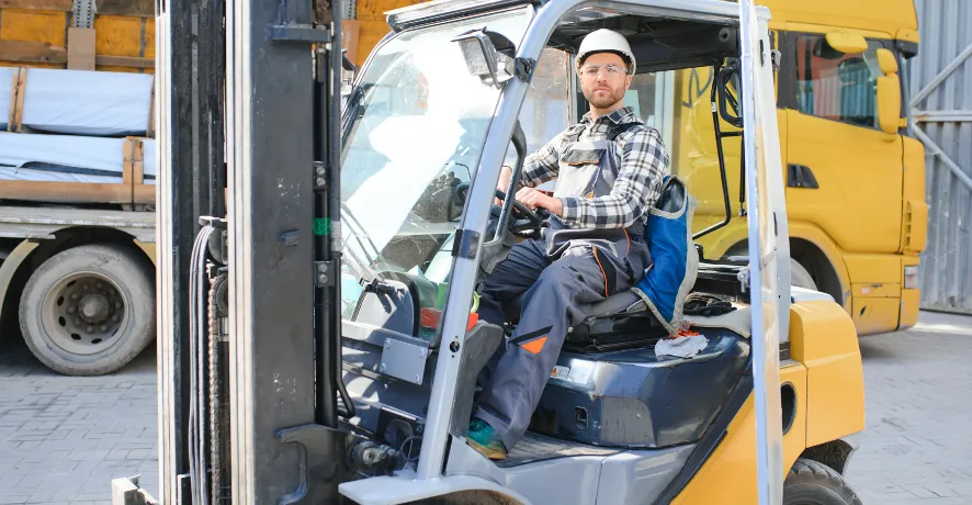 2 Warehouse staff driving a commercial lifter for freight operations