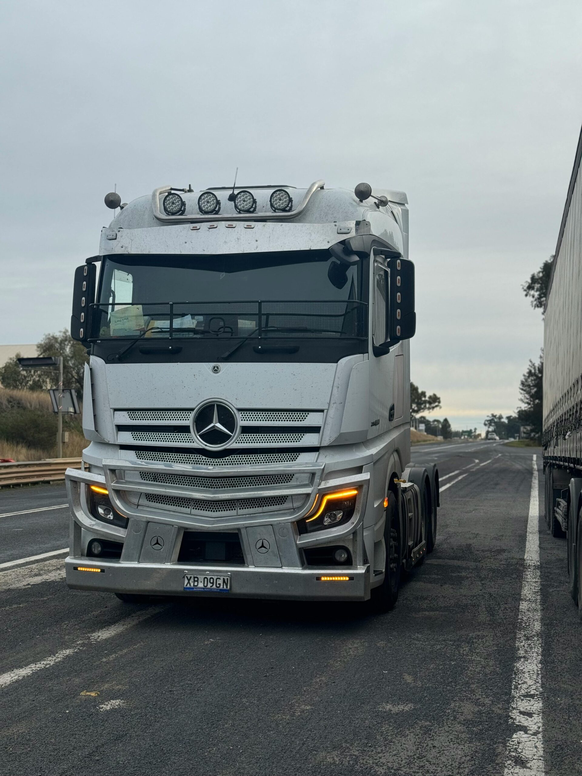 pexels-photo-28264506-28264506 A sleek white truck travels along a highway, showcasing modern transportation.