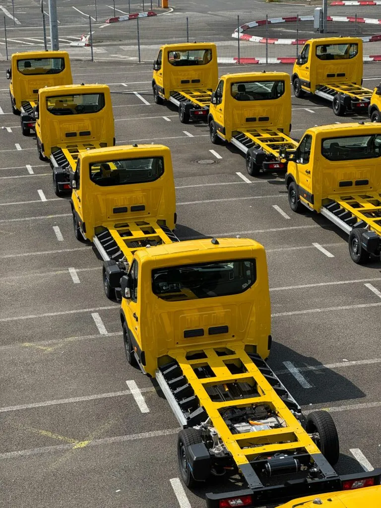 pexels-photo-33358653-33358653 Yellow truck chassis neatly lined up in a Cologne parking lot, showcasing industrial precision and organization.