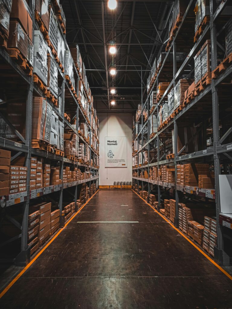 pexels-photo-5860937-5860937 A well-organized warehouse aisle with stacks of goods on industrial storage racks, ensuring efficient logistics.